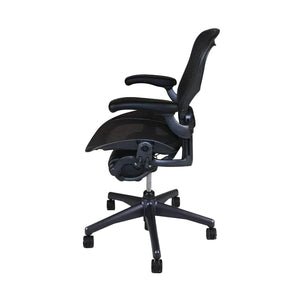 Graphite Herman Miller Aeron office chair with fixed arms, known for its ergonomic design and comfort, displayed against a white background. Side view.